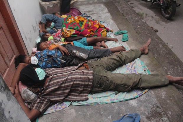 Villagers sleep at a temporary shelter after they were evacuated from their homes