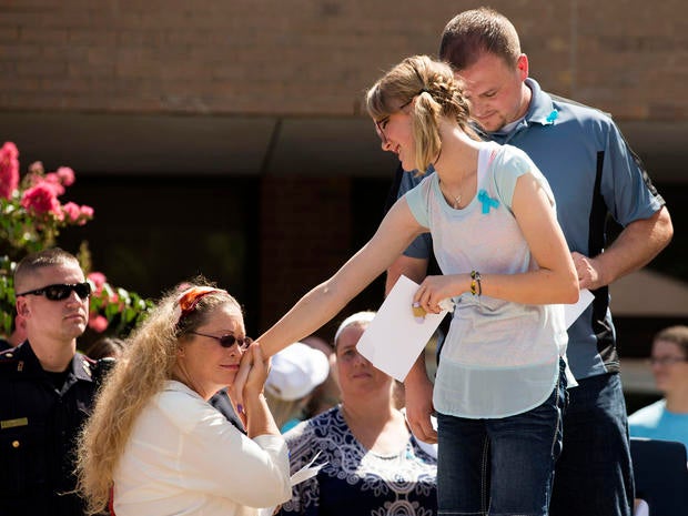A supporter greets Cassidy Stay, far right, lone survivor of the mass shooting of her parents and siblings, during a community memorial celebrating the lives of the Stay family at Lemm Elementary School July 12, 2014, in Spring, Texas.