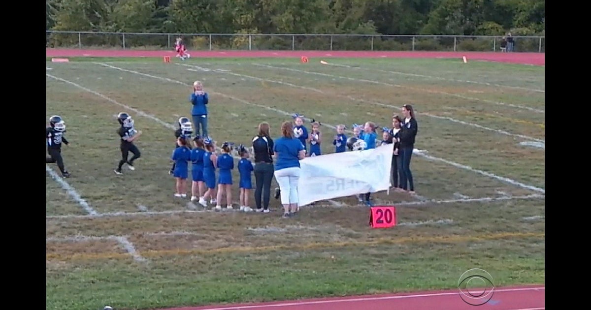 football team running through banner