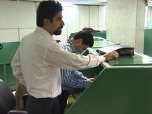 Iranian stock trader Mojtaba Shabazi at work on the floor of the Tehran Stock Exchange