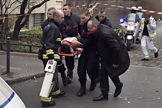 A victim is evacuated on a stretcher, Jan. 7, 2015, after armed gunmen stormed the offices of the French satirical newspaper Charlie Hebdo