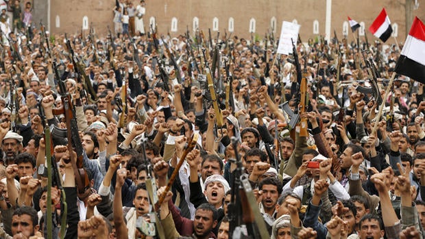 Shi'ite Muslim rebels hold up their weapons during a rally against airstrikes in Sanaa, Yemen, March 26, 2015.