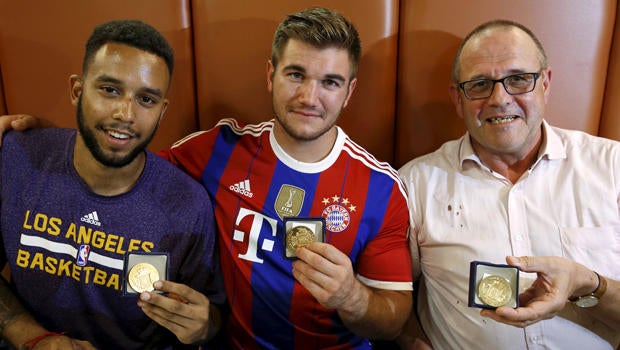 Three men who helped disarm an attacker on a train from Amsterdam to France, from left, Anthony Sadler, from Pittsburg, California, Aleck Sharlatos, from Roseburg, Oregon, and Chris Norman, a British man living in France, pose with medals they received f