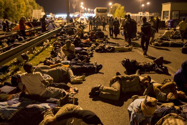 Migrants sleep on a highway in front of a barrier at the border with Hungary near the village of Horgos, Serbia