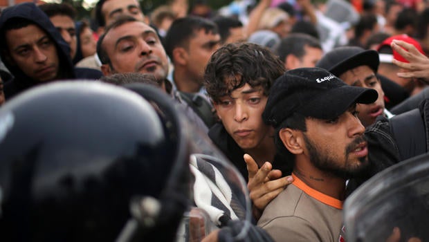 Migrants are held back by Slovenian riot police at the border in the small Croatian village of Harmica Sept. 19, 2015, in Harmica, Croatia.