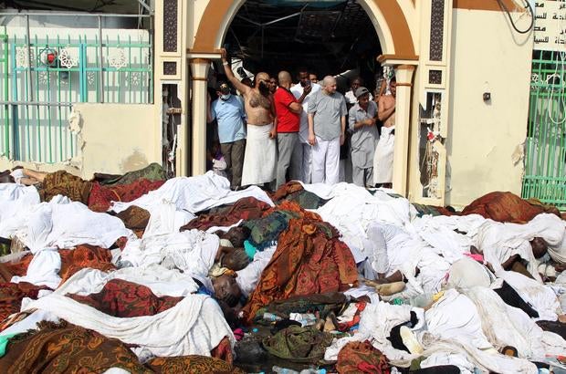 Saudi emergency personnel stand near bodies of Hajj pilgrims at the site where at least 717 were killed and hundreds wounded in a stampede in Mina, near the holy city of Mecca, at the annual hajj in Saudi Arabia