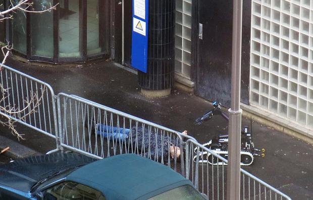 French police use a bomb disposal robot to inspect the body of a man shot dead at a police station in the 18th district in Paris