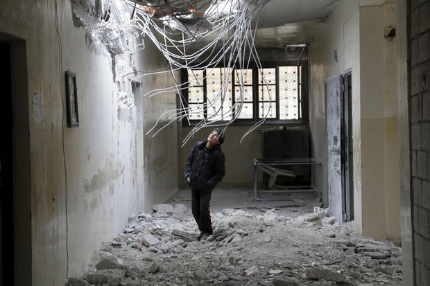 A boy inspects damage inside his school due to what activists said was an airstrike carried out by the Russian air force in Injara, Syria, Jan. 12, 2016.