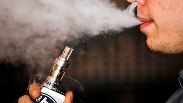 A man smokes an electronic cigarette vaporizer, also known as an e-cigarette, in Toronto Aug. 7, 2015.