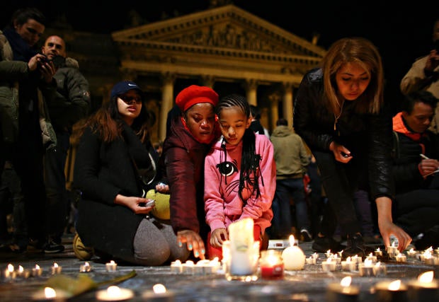 A young girl lights a candle at the Place de la Bourse following attacks in Brussels, Belgium, on March 22, 2016.