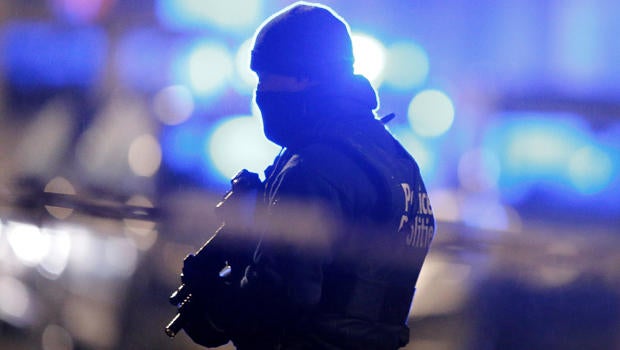 A masked Belgian police officer takes part in police operations in the Schaerbeek area of Brussels, Belgium, March 25, 2016, three days after bomb attacks in the Belgian capital.