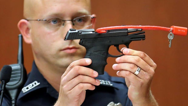 Sanford police officer Timothy Smith holds up the gun that was used to kill Trayvon Martin while testifying during George Zimmerman's murder trial in Seminole circuit court in Sanford, Florida, June 28, 2013.