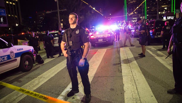 Police officers stand guard at a barricade following the sniper shooting in Dallas on July 7, 2016.
