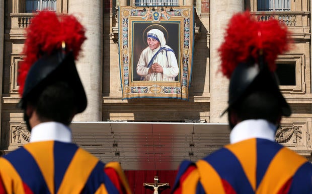 Swiss Guards stand in front of a tapestry depicting Mother Teresa of Calcutta before a mass, celebrated by Pope Francis, for her canonisation in Saint Peter’s Square