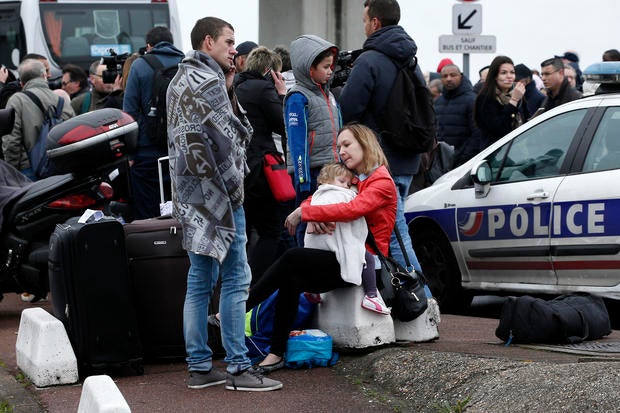 Travelers wait outside the Orly airport, south of Paris, March 18, 2017.