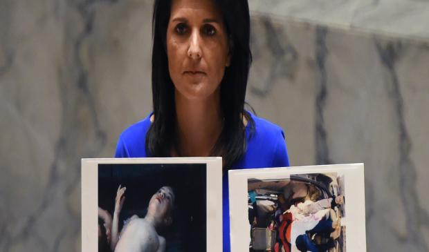 U.S. Ambassador to the U.N. Nikki Haley holds photos of victims as she speaks as the U.N. Security Council meets in an emergency session at the U.N. on April 5, 2017. 