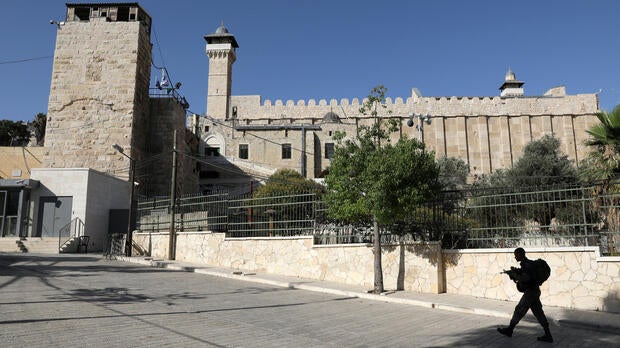 An Israeli soldier walks past Ibrahimi Mosque, which Jews call the Tomb of the Patriarchs, in the West Bank city of Hebron July 7, 2017.