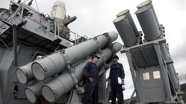 U.S. Navy personnel stand in front of a guided missile launcher during a bilateral maritime exercise between the Philippine navy and U.S. Navy aboard the USS John S. McCain in the South China Sea near waters claimed by Beijing on June 28, 2014.