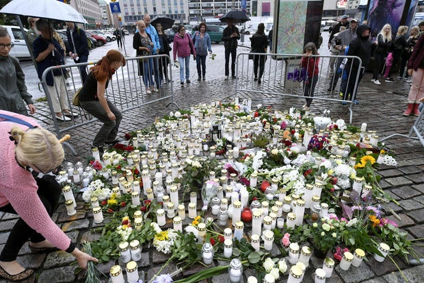 People bring memorial candles and flowers to the Turku Market Square for the victims of Friday's stabbings in Turku