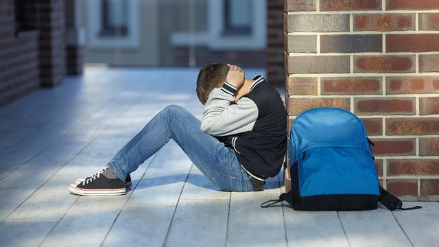 schoolboy crying in the hallway of the school