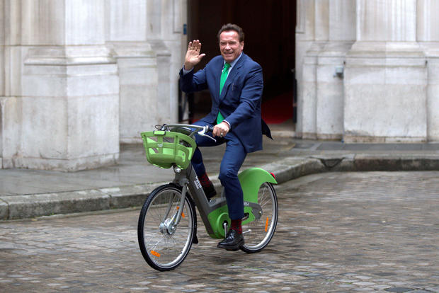 R20 founder and former California state governor Arnold Schwarzenegger rides the new Velib' bicycle as he arrives at a news conference ahead of the One Planet Summit in Paris 