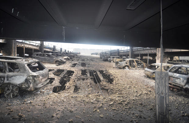 Burnt cars are seen in what remains of the multi-storey car park, where a large fire destroyed many cars on Sunday, in King's Dock, Liverpool 