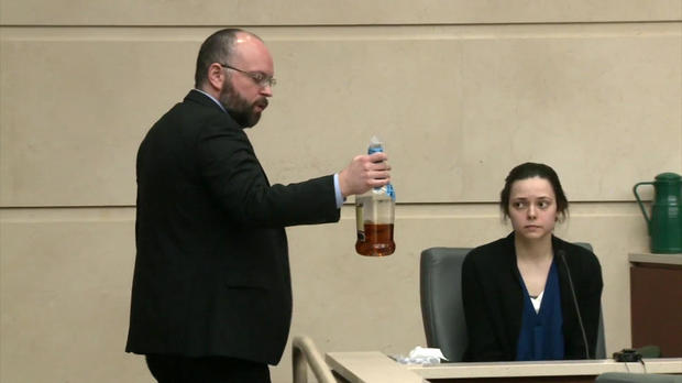 Shana Elliott looks at a liquor bottle recovered from her car as she testifies in San Marcos, Texas, on March 8, 2018. 