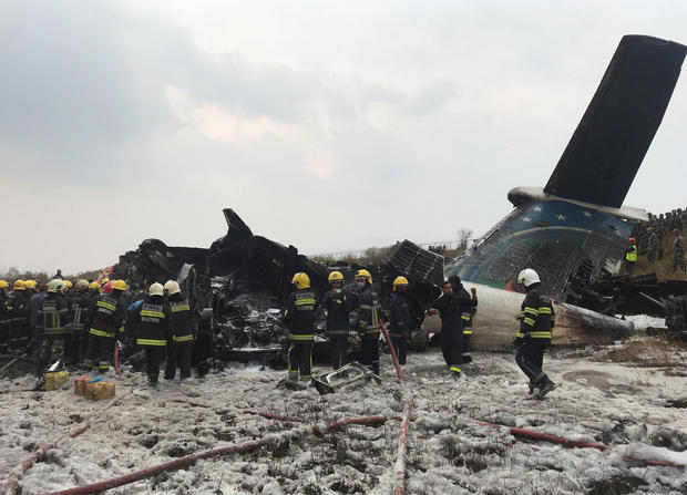 Wreckage of an airplane is pictured as rescue workers operate at Kathmandu airport 