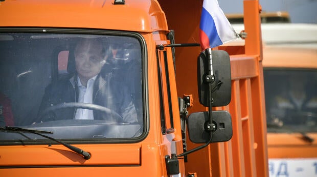 Russian President Vladimir Putin drives a Kamaz truck during a ceremony opening a bridge to connect the Russian mainland with the Crimean peninsula across the Kerch Strait, May 15, 2018.