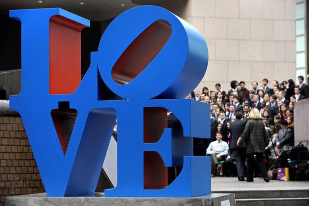 A sculpture by artist Robert Indiana is displayed in a public area in Hong Kong on March 9, 2008, as people gather for a group photo. The sculpture is inspired from Indiana's "Love" painting from the 1960s.