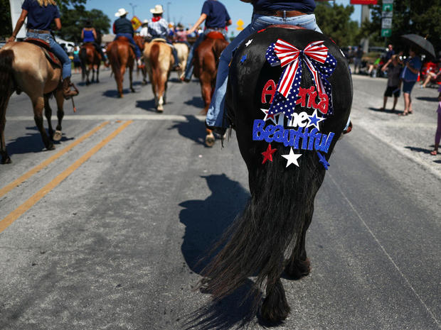 Sign hangs from tail of horse during Memorial Day Parade in Bandera, Texas 