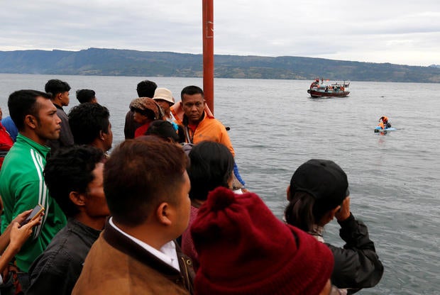 Local residents and relatives of missing passengers from a ferry accident on Lake Toba, wait on the dock at Tigaras Port in Simalungun