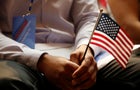 A new citizen holds a U.S. flag at the U.S. Citizenship and Immigration Services (USCIS) naturalization ceremony at the New York Public Library in Manhattan 
