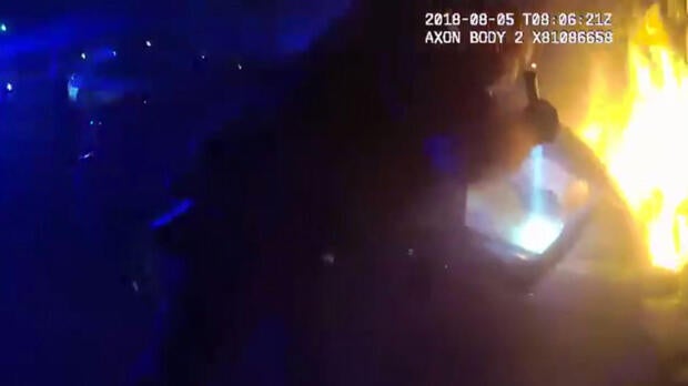 An Atlanta police officer works to free a passenger from a trapped car on Aug. 5, 2018, in this image capture from footage from another officer's body camera.