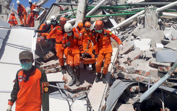 A search and rescue team evacuates a victim from the ruins of the Roa-Roa Hotel in Palu, Central Sulawesi, 