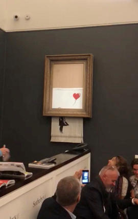 Banksy's painting "Girl with Red Balloon" is seen shredded after its sale at Sotheby auction in London 