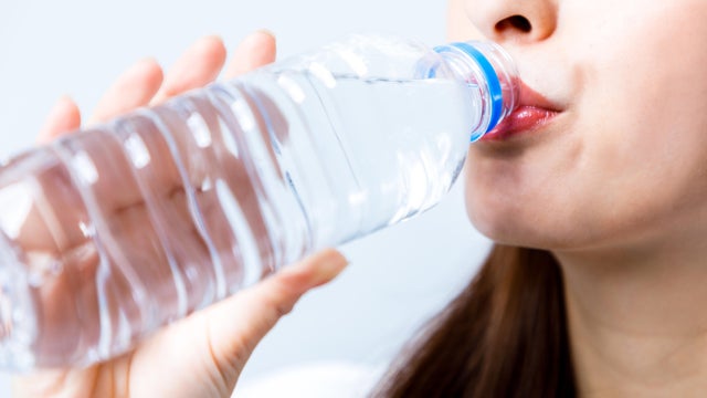 woman drinking plastic bottle of water