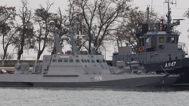 Seized Ukrainian ships, small armoured artillery ships and a tug boat, are seen anchored in a port of Kerch 