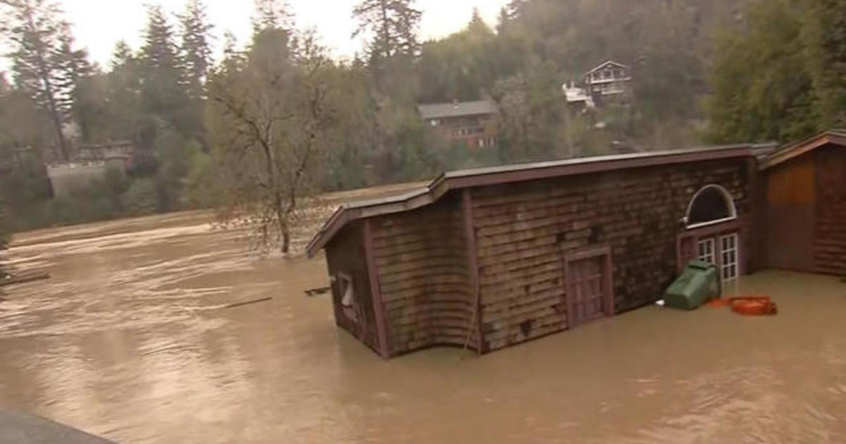 California town trapped by floodwaters after river overflows CBS News