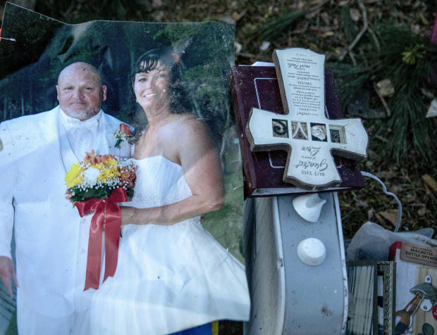 A wedding photo of Carol Dean and David Wayne Dean sits in a pile of personal items Carol Dean recovered while sifting through the debris after a tornado destroyed their home a day earlier killing her husband in Beauregard, Alabama, March 4, 2019. 