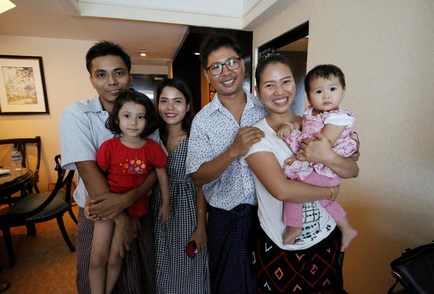 Reuters reporter Wa Lone poses with wife Pan Ei Mon and daughter, along with Reuters reporter Kyaw Soe Oo carrying his daughter next to wife Chit Su Win, after being freed from prison, after receiving a presidential pardon in Yangon 