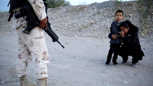 Guatemalan migrant Ledy Perez embraces her son Anthony while asking a member of the Mexican National Guard to let them cross into the United States from Ciudad Juarez, Mexico, July 22, 2019. 