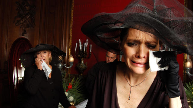 Two Women Dressed in Black and Crying at Funeral 