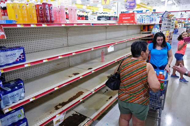 Nearly empty shelves where bottled water is normally displayed, are shown at a grocery store as Tropical Storm Dorian approaches in Cabo Rojo 