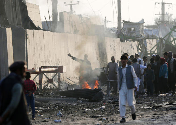 Angry Afghan protesters burn tires and shout slogans at the site of a blast in Kabul, Afghanistan 