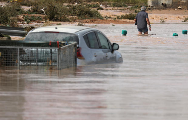 A man wades through a flooded street after heavy rains in San Javier 