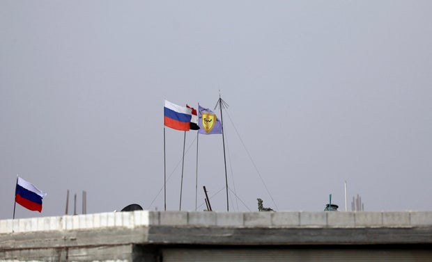 Russian, Syrian and Manbij military council flags flutter near Manbij