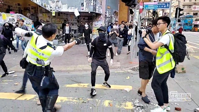 A still image from a social media video shows a police officer aiming his gun at a protester in Sai Wan Ho, Hong Kong