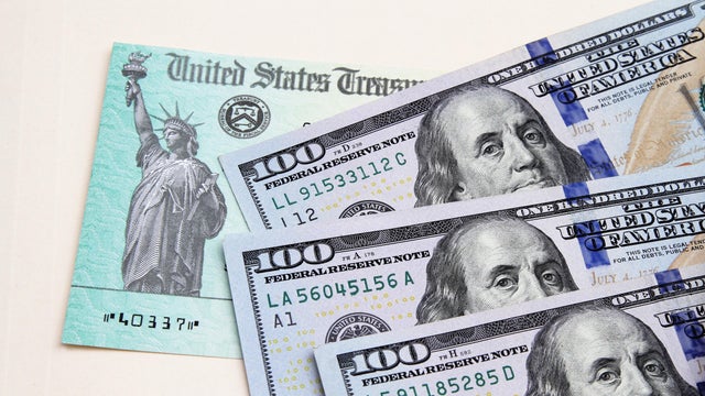 Tax refund check from US Treasury and US currency 100 dollar bills
