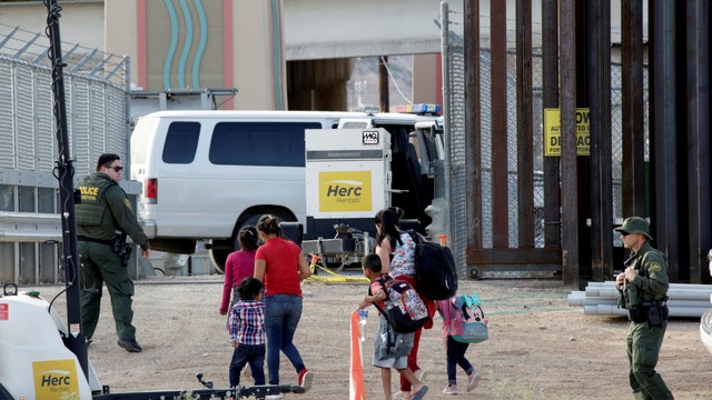 FILE PHOTO: CBP agents look at migrants who crossed illegally into El Paso, Texas, U.S. to turn themselves in to ask for asylum as seen from Ciudad Juarez